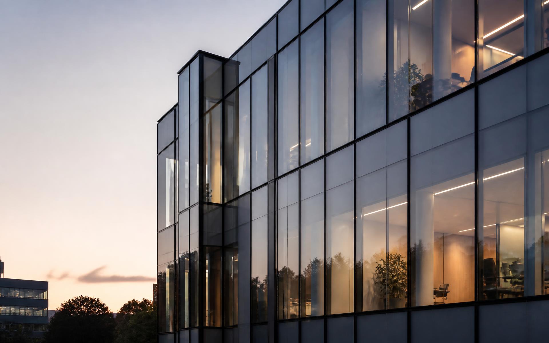 Modern glass and aluminum curtain wall facade at dusk